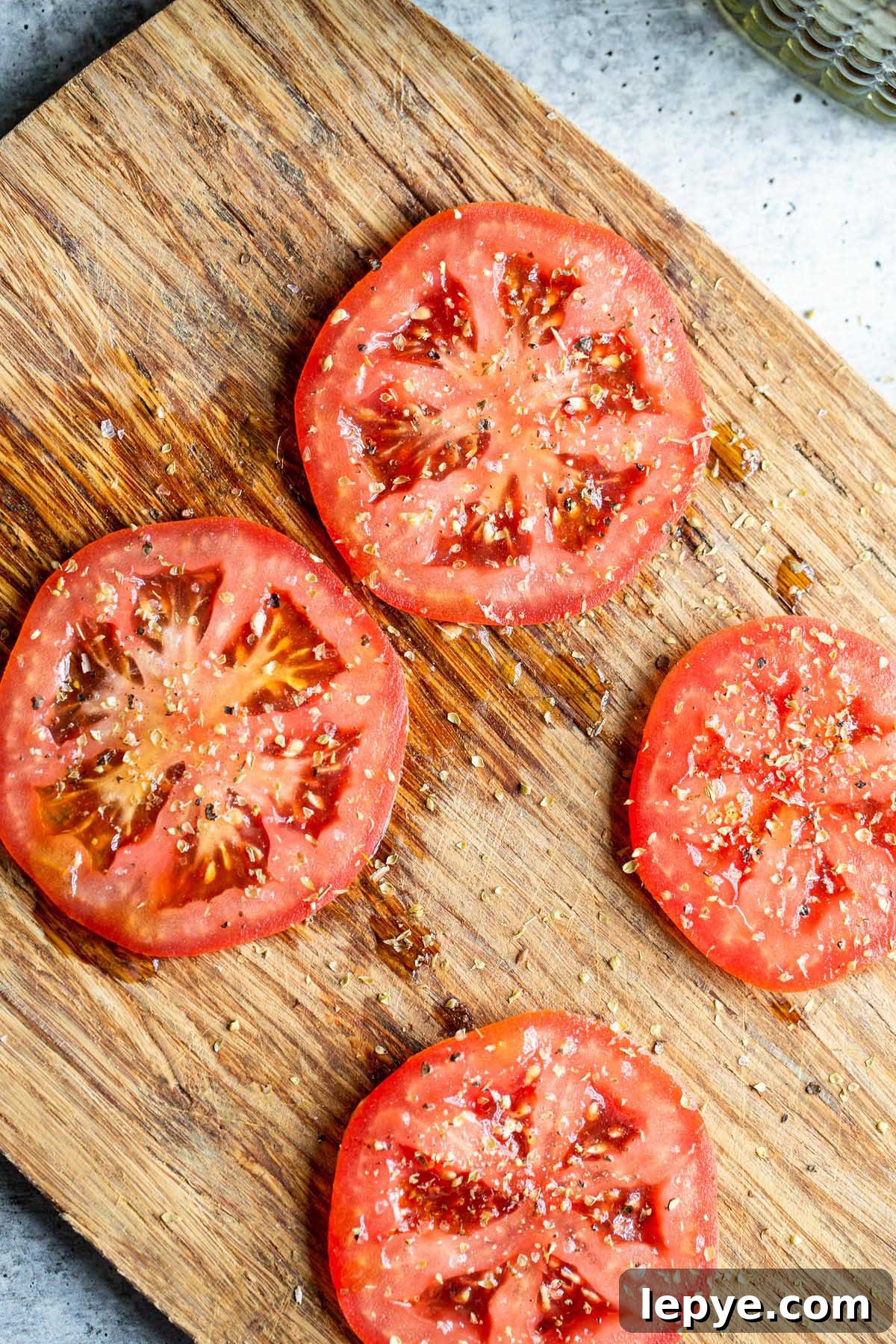 Crispy Parmesan Air Fryer Tomatoes Recipe 4 Tomato slices on a cutting board.