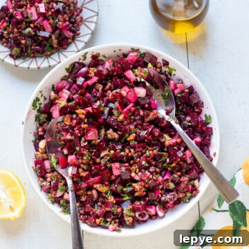 Chimichurri Lentil and Roasted Beet Salad for Spring Meals 7 overhead view of large bowl of chimichurri lentil and beet salad with a jug of extra virgin olive oil , half a lemon and a small plate of salad surrounding the large bowl