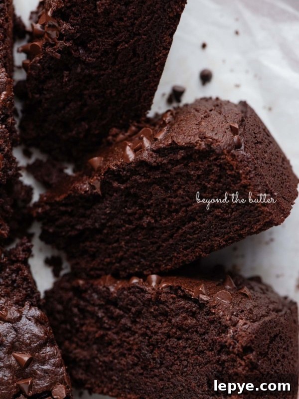 Slices of chocolate ricotta cake on their sides placed on white parchment paper and light pink background.