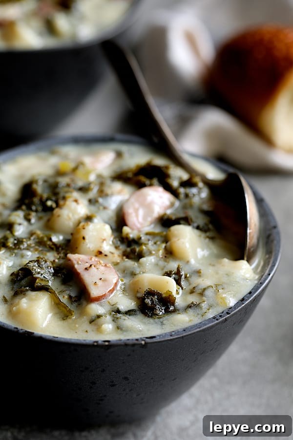 Creamy Kielbasa, Potato & Kale Soup Recipe 7 Close-up photo of Creamy Potato Kielbasa and Kale Soup in gray bowl.