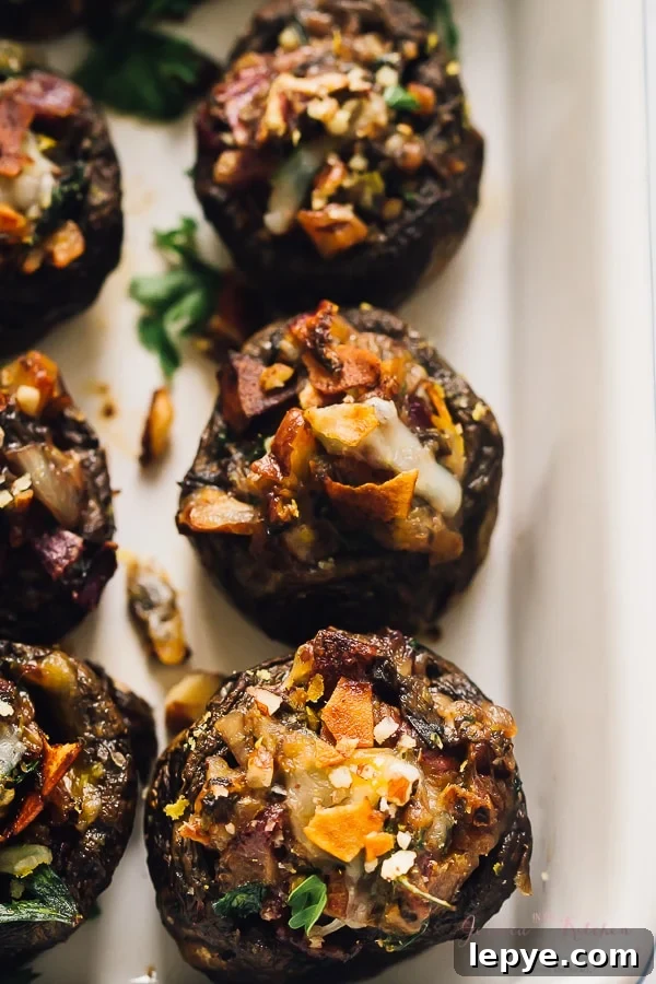 Top down shot of stuffed mushrooms in a baking tray.