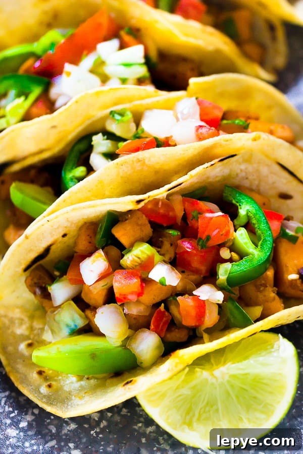 Close up of sweet potato tacos with a wedge of lime.