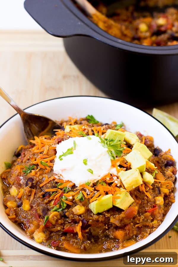 Sweet potato and black bean chili in a white bowl with sour cream on top.