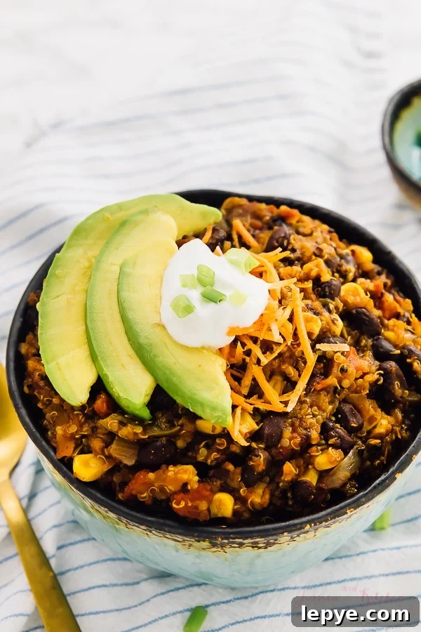 Vegan Chili in a blue bowl with slices of avocado on top.