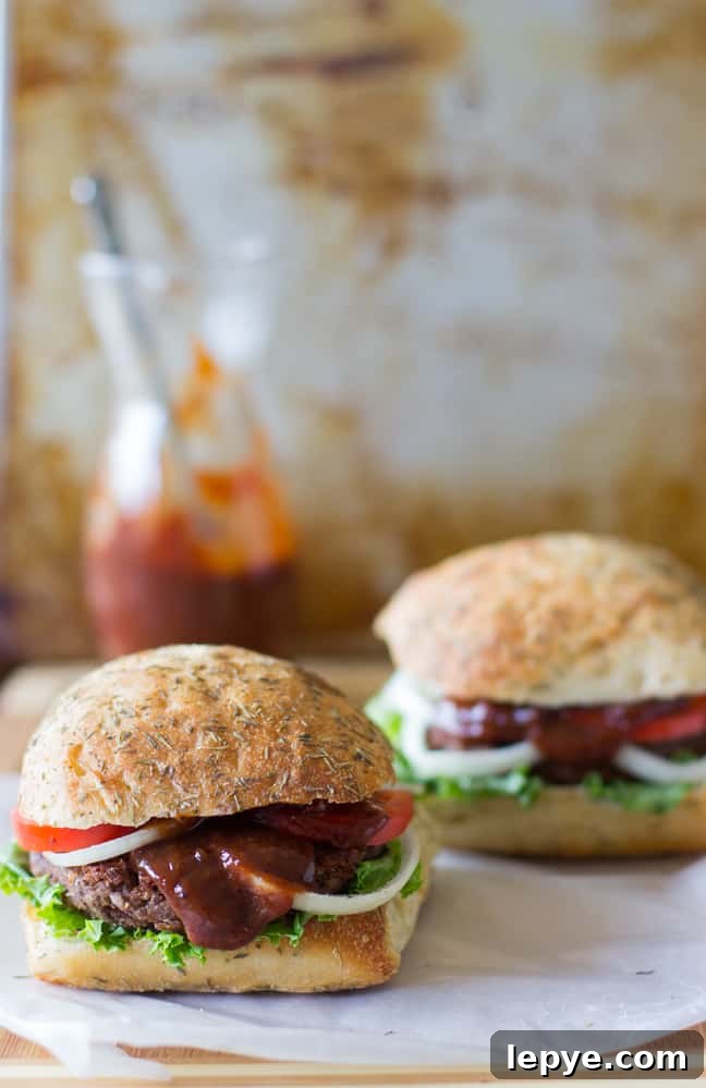 Side shot of two quinoa burgers on parchment.