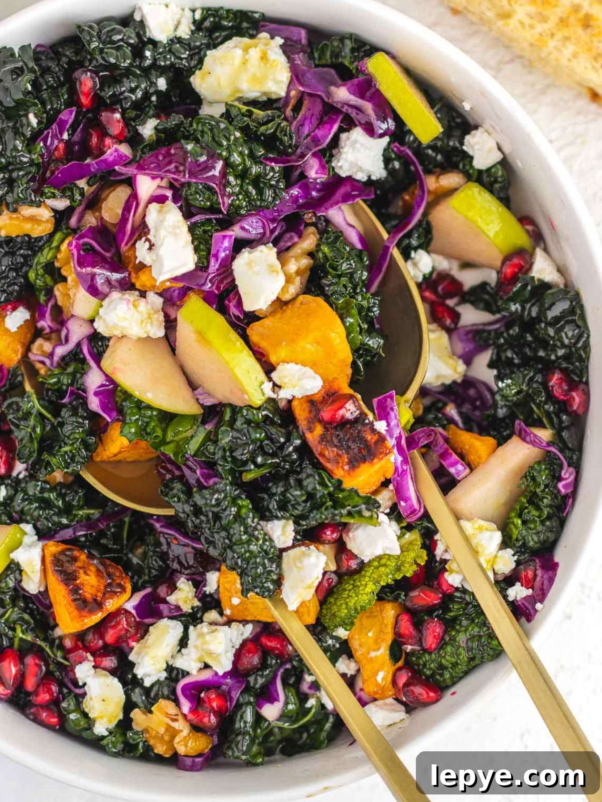 Roasted Butternut Squash and Kale Salad with Quinoa and Cranberries 2 Top down view of colorful butternut squash kale salad with feta walnuts and pomegranate seeds.