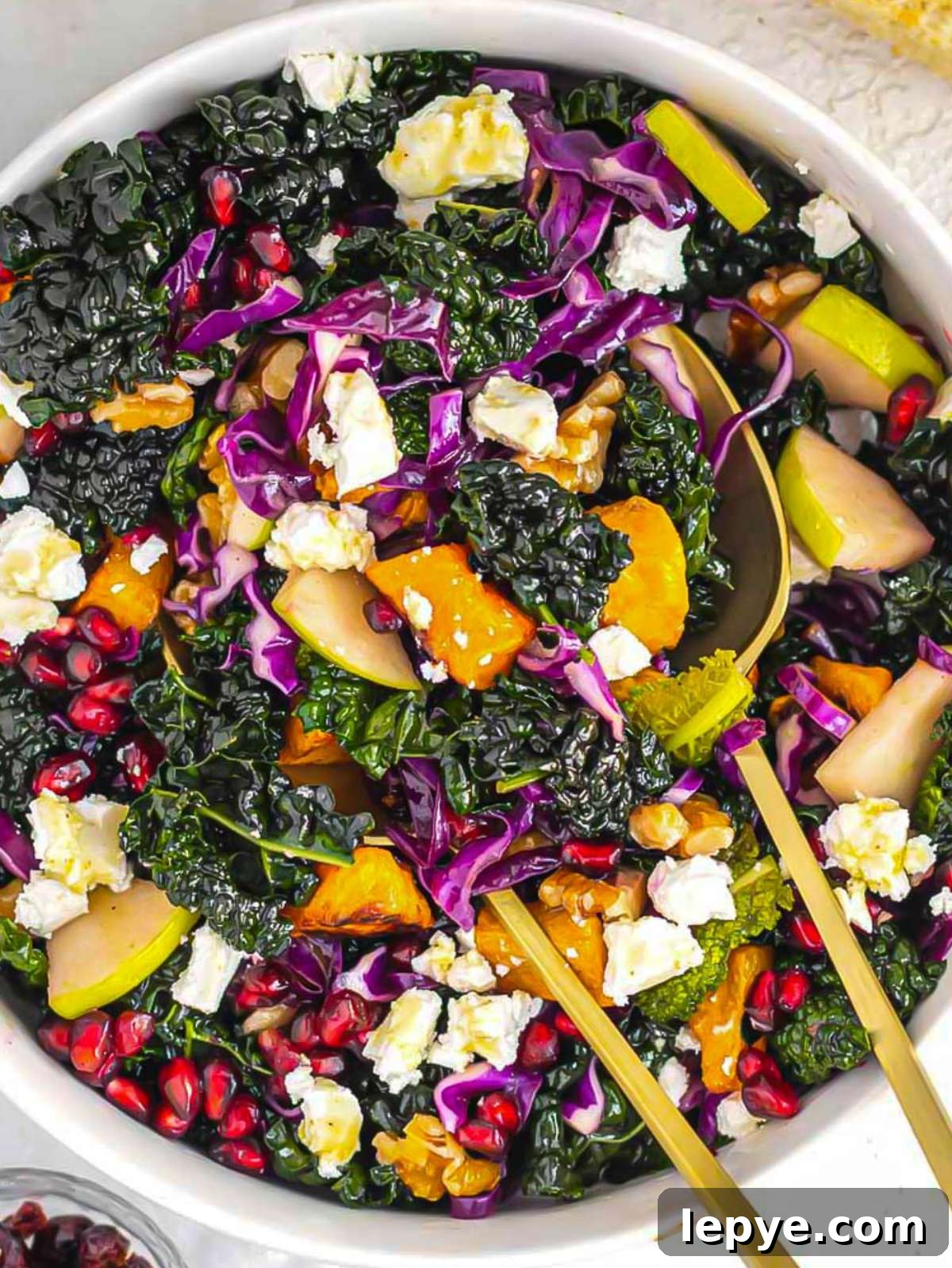 Roasted Butternut Squash and Kale Salad with Quinoa and Cranberries 4 Healthy butternut squash kale salad with honey mustard dressing walnuts apple and pomegranate close up.