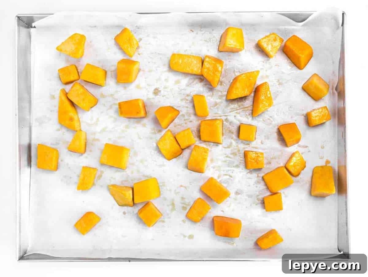 Roasted Butternut Squash and Kale Salad with Quinoa and Cranberries 5 Step 1 Cubes of butternut squash roasting on a baking tray until tender and golden.