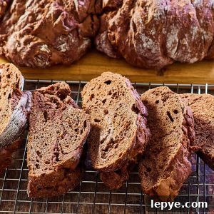 Classic Chocolate Babka Recipe: Swirled Yeast Bread Tutorial 12 Angled view of slices of chocolate bread sitting on a cooling rack. Hostess At Heart