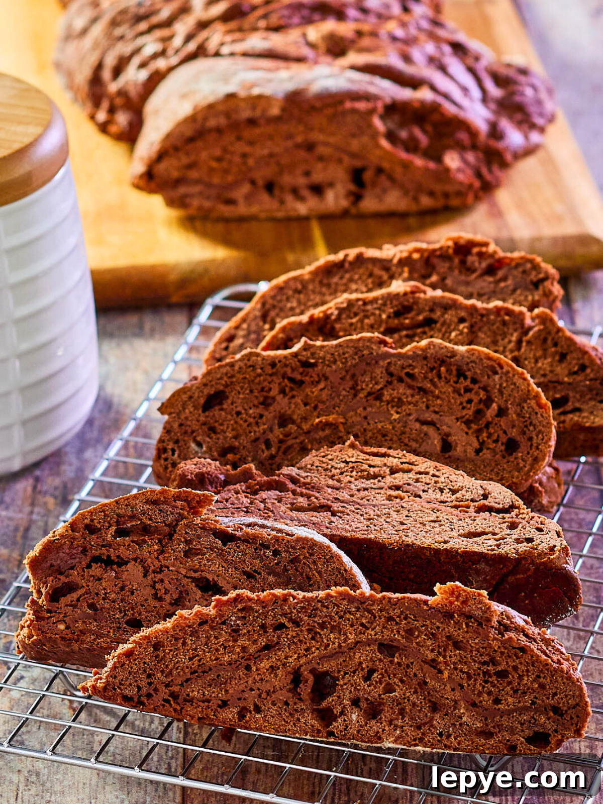 Classic Chocolate Babka Recipe: Swirled Yeast Bread Tutorial 10 Angled view of deep chocolate bobca bread sliced on a cooling rack - Hostess At Heart