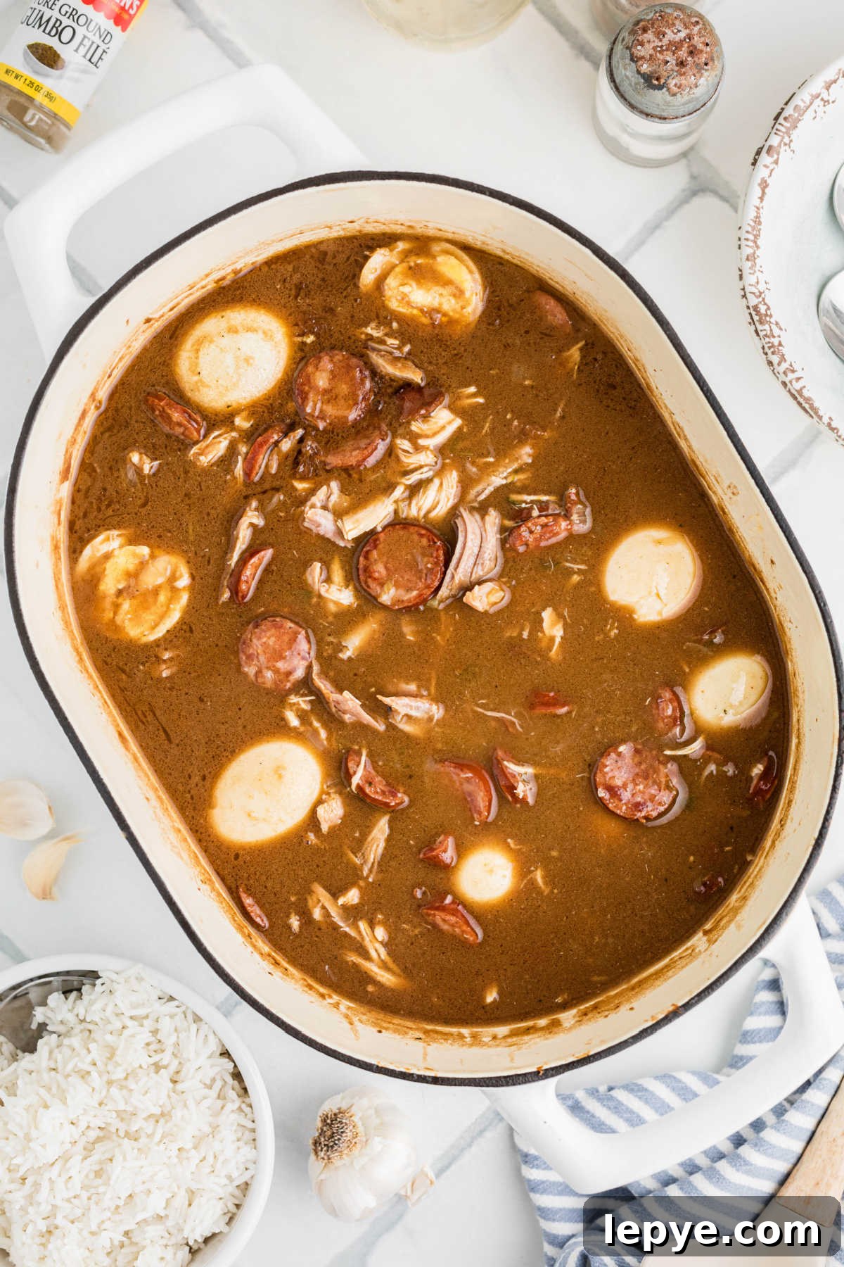Overhead shot of a pan with leftover turkey and andouille sausage gumbo, with boiled eggs.