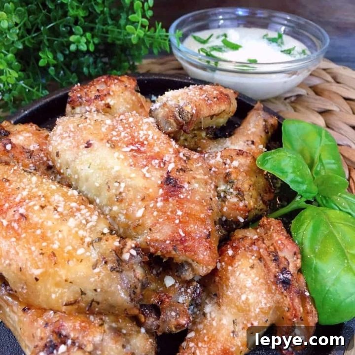 Air Fryer Parmesan Wings on a iron skillet with dipping sauce