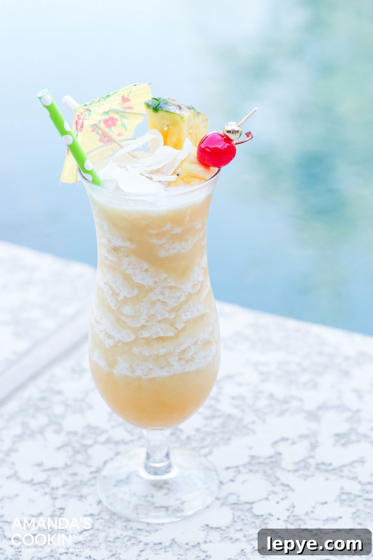 a frosty pina coloada drink sitting by the pool