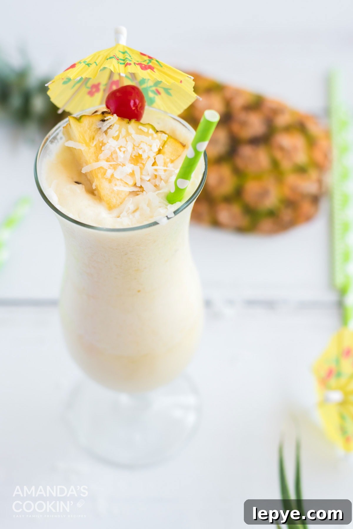 white pina colada with cherry and pineapple garnish