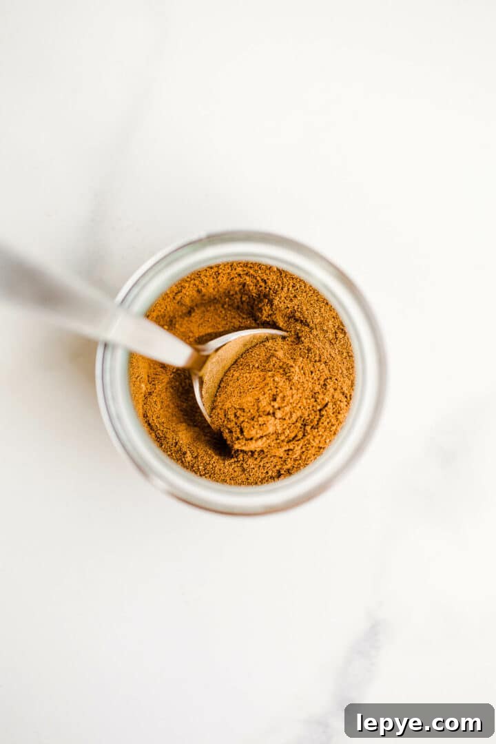 Homemade Pumpkin Pie Spice Blend for Baking and Drinks 6 Pumpkin pie spice in jar with spoon.