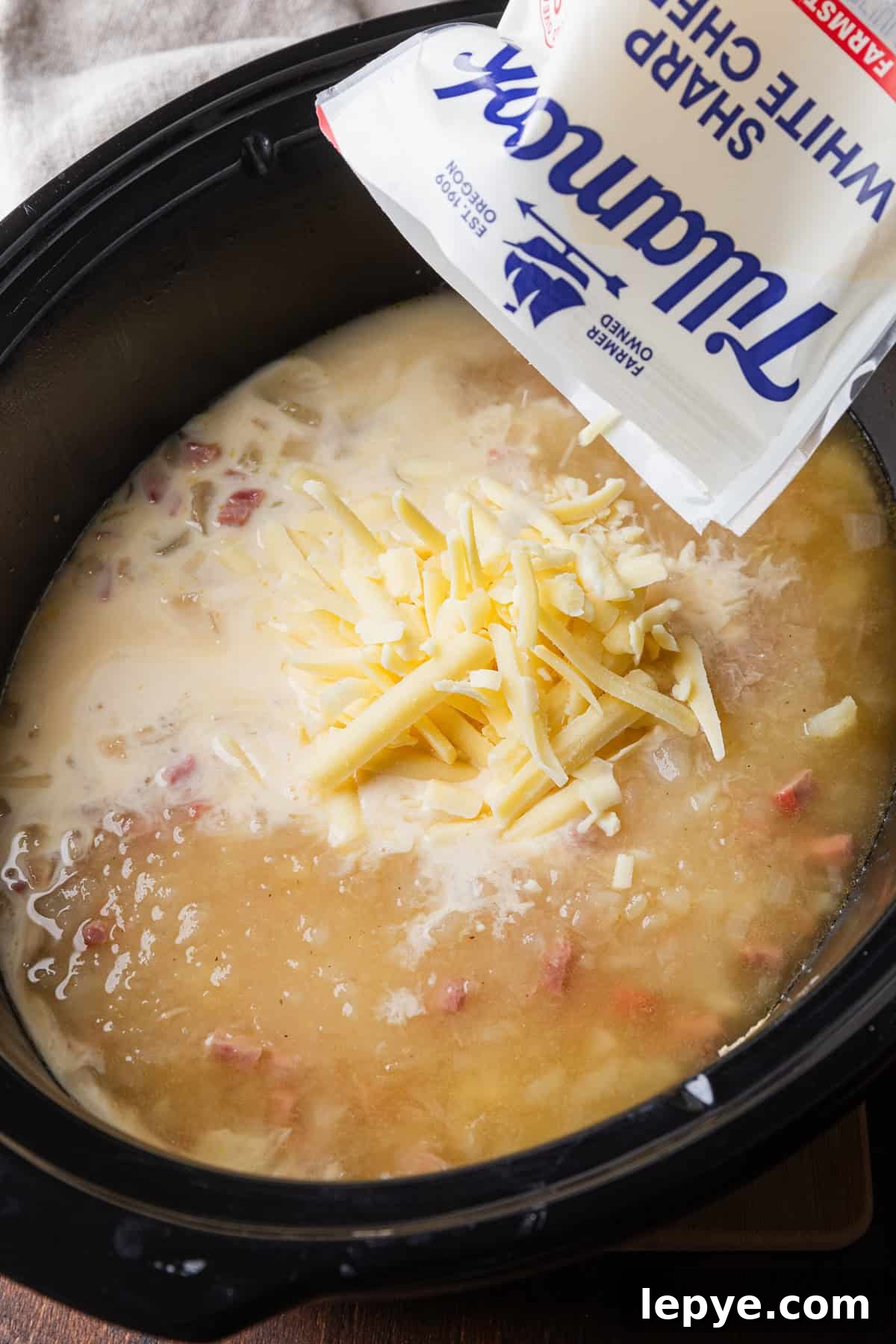 Crockpot Potato Soup with Evaporated Milk — Creamy Dinner Recipe 8 Adding shredded cheese to the soup.