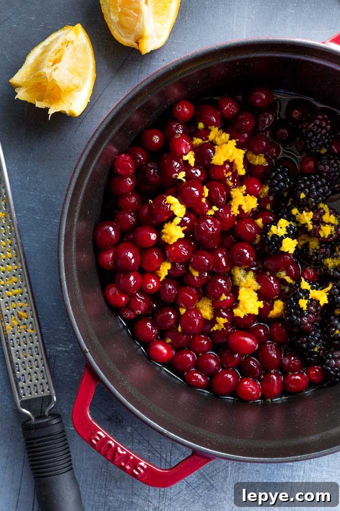 Ingredients to make healthy cranberry sauce in a large pot.