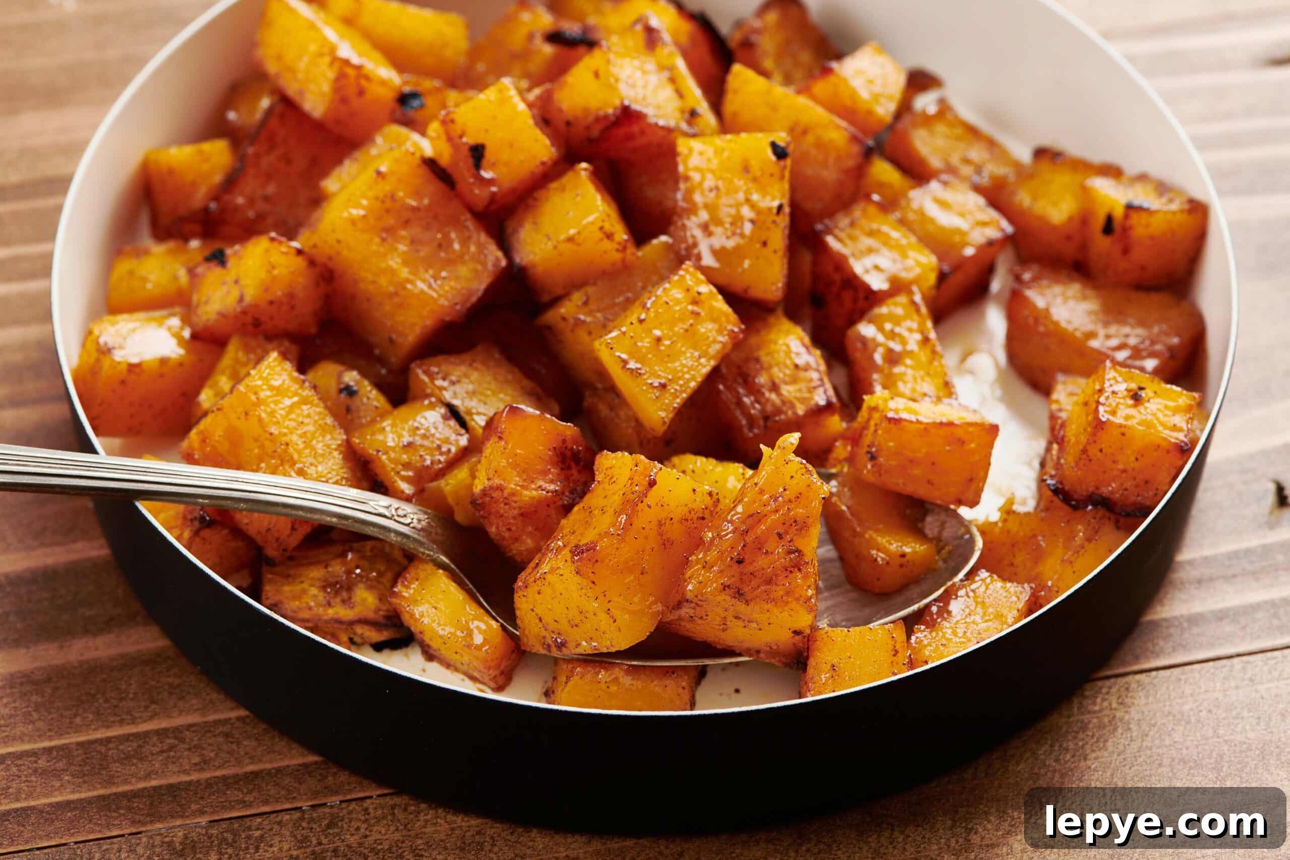 Maple Roasted Butternut Squash in serving dish with spoon.