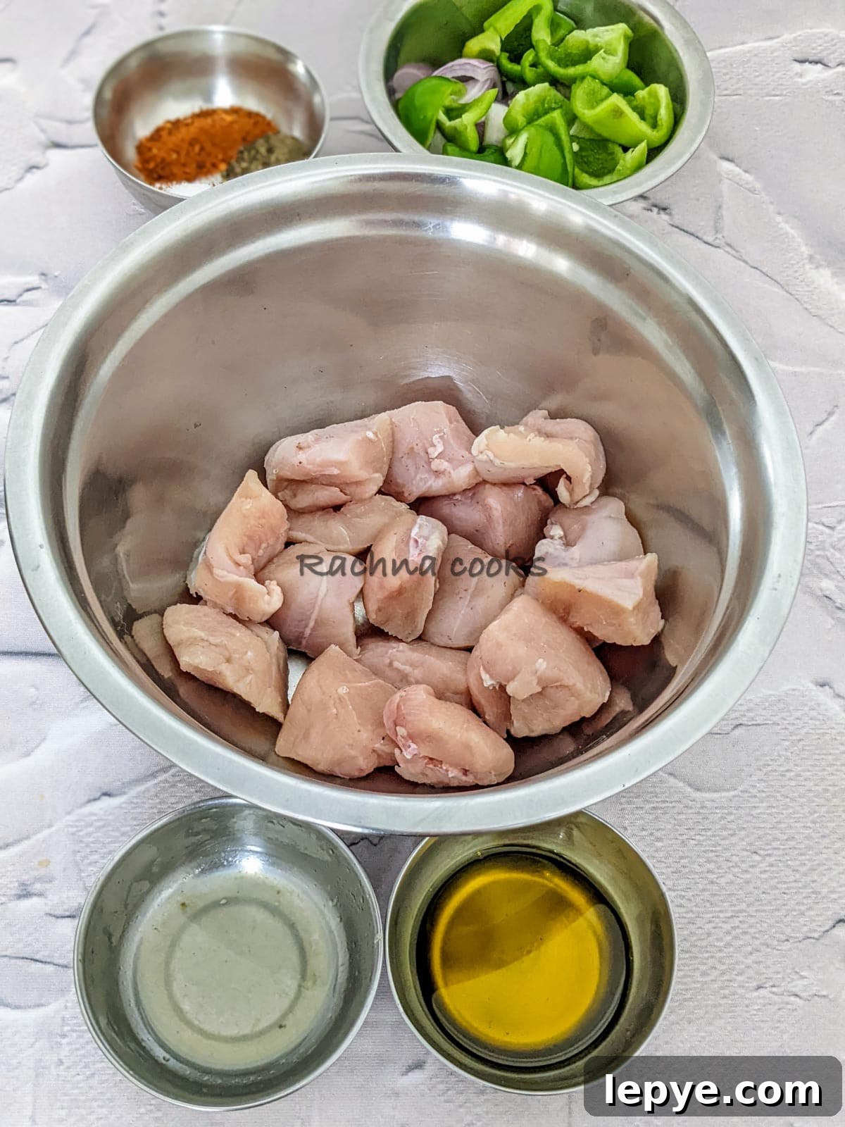 Chicken cubes, oil. lemon juices, spices and cut pepper and onion in a bowl.