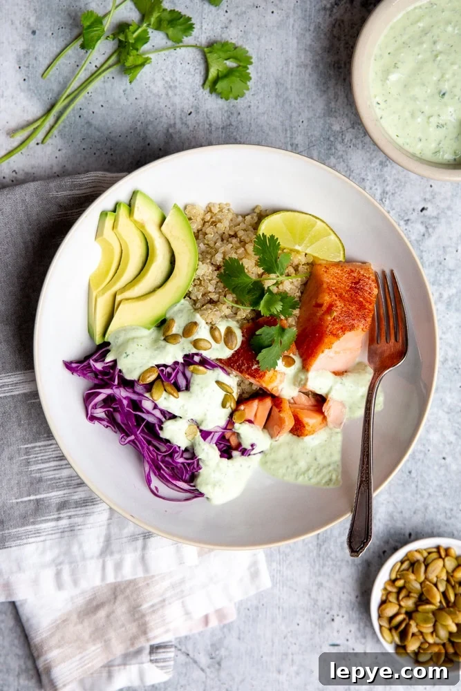 Grain bowl with salmon, cabbage and avocado, drizzled with cilantro yogurt sauce. 