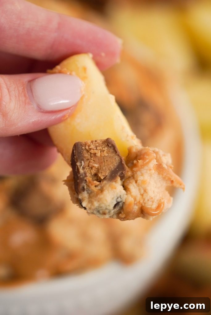 apple slice with peanut butter cup cream cheese dip on it