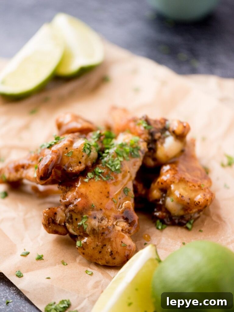 Citrus Tequila-Lime Chicken Wings Recipe for Game Day 11 Lime wedges on parchment paper next to tequila lime wings.