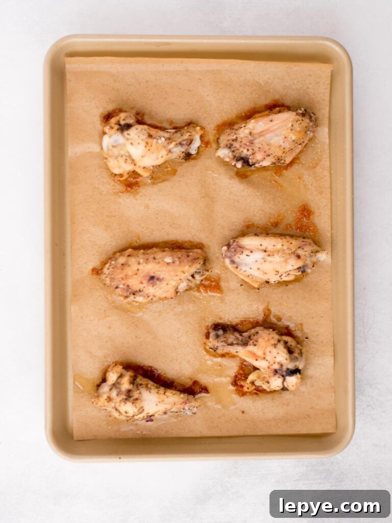 Citrus Tequila-Lime Chicken Wings Recipe for Game Day 6 Seasoned chicken wings on a baking sheet.