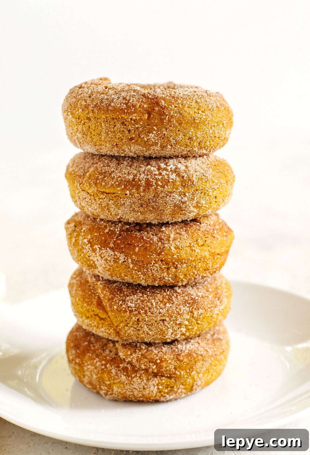 Gluten-Free Pumpkin Spice Donuts Recipe with Crispy Glaze 4 Pumpkin donuts cooling on a rack