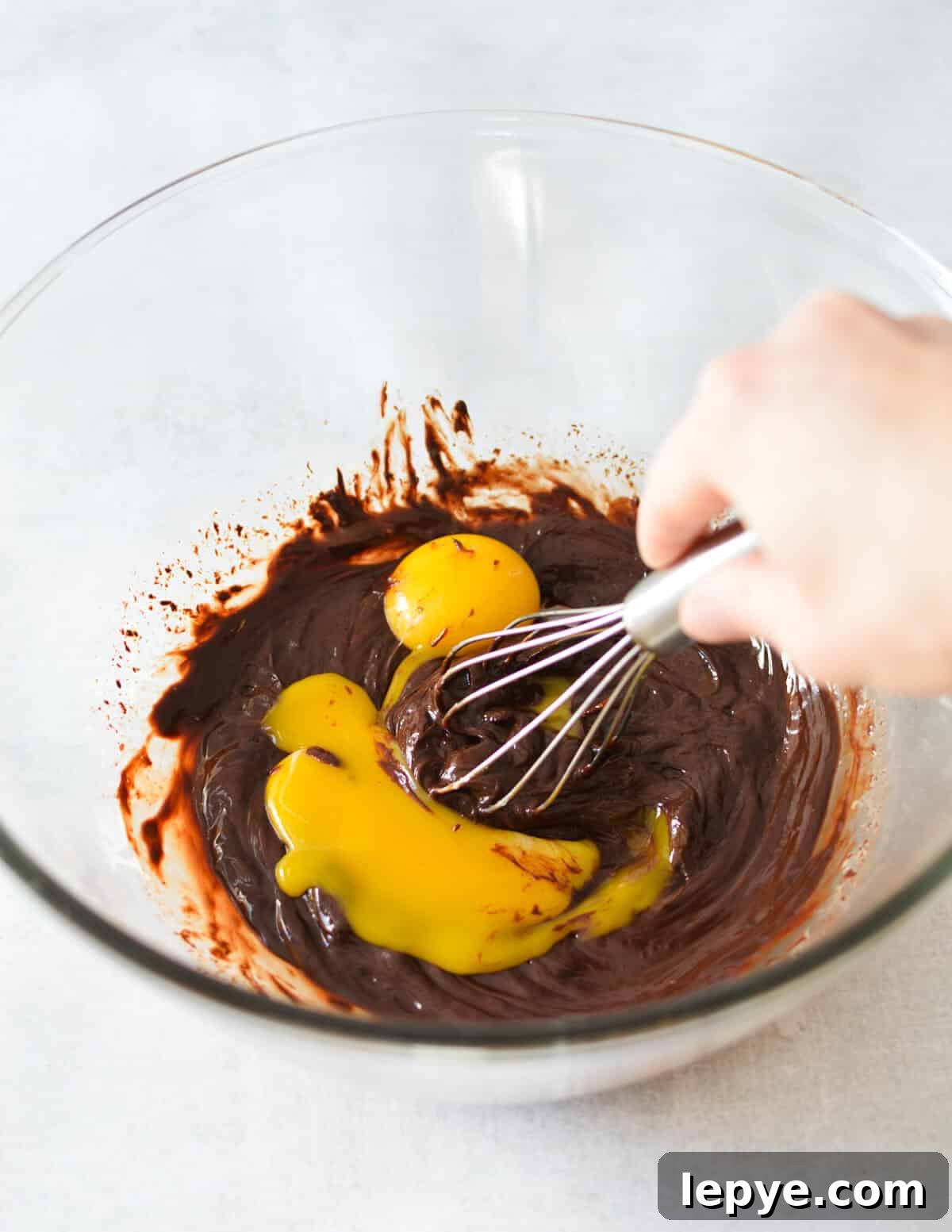Decadent Chocolate Mousse Recipe for Silky, No-Bake Perfection 11 whisking egg yolks into melted chocolate.