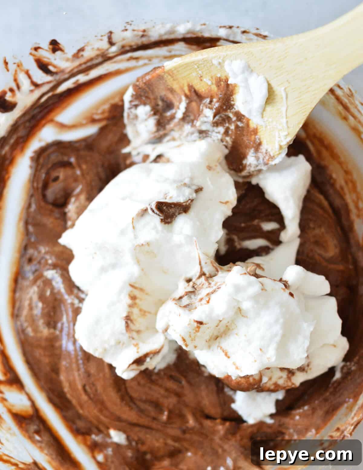 Decadent Chocolate Mousse Recipe for Silky, No-Bake Perfection 14 egg whites getting stirred into chocolate mousse.
