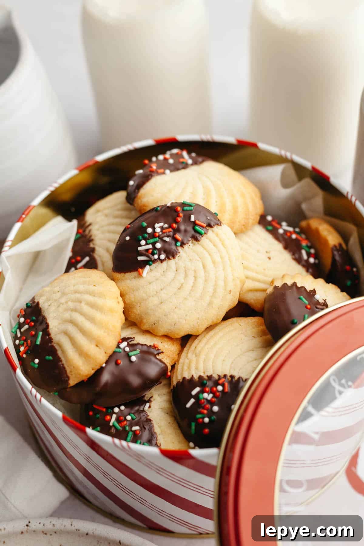 Danish Butter Cookies Dipped in Rich Chocolate 2 Chocolate dipped butter cookies with sprinkles in a tin.