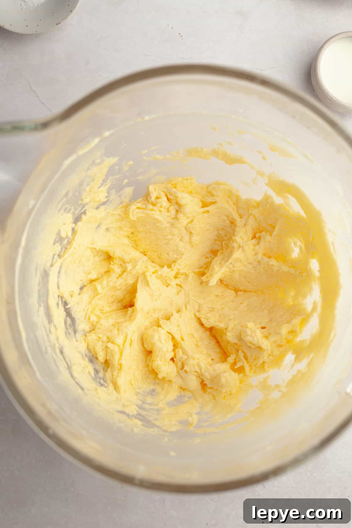Danish Butter Cookies Dipped in Rich Chocolate 5 A large glass bowl with yellow cookie dough in it.