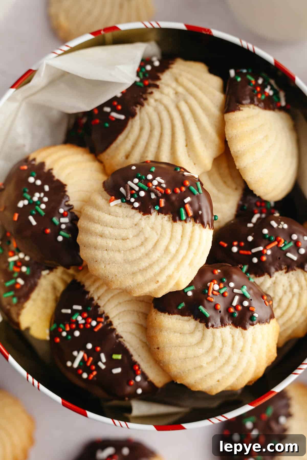 Danish Butter Cookies Dipped in Rich Chocolate 10 Chocolate dipped butter cookies with sprinkles in a tin.