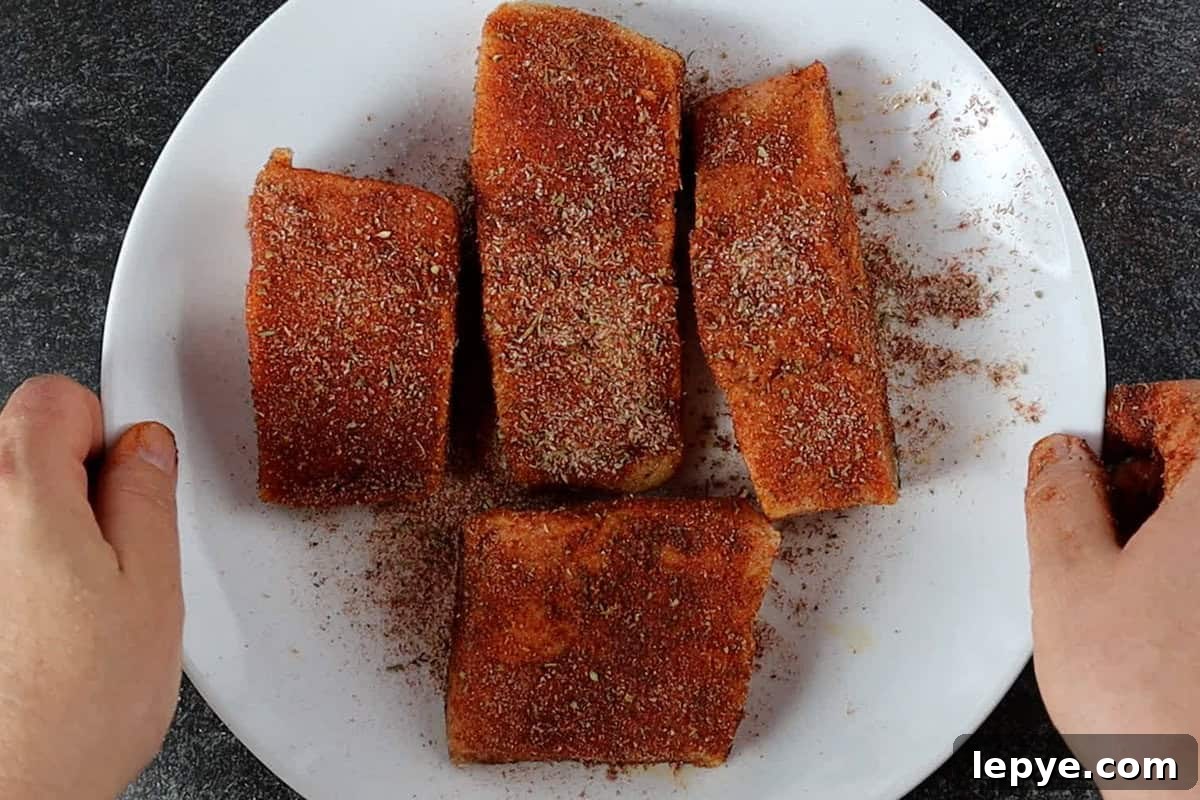 Grilled Salmon with Fresh Mango Salsa Recipe 8 salmon filets coated with dry rub on white plate.