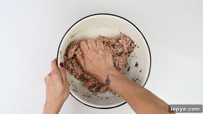 Authentic Lamb Kofta Recipe: Juicy Middle Eastern Meatballs 6 Mixing meat mixture by hand in a large bowl