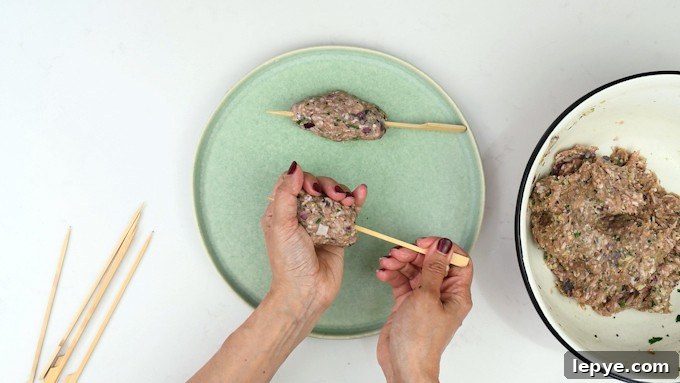 Authentic Lamb Kofta Recipe: Juicy Middle Eastern Meatballs 7 Threading lamb kofta onto bamboo skewers