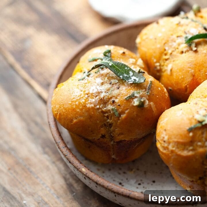 Soft, fluffy gluten free pumpkin dinner rolls with sage garlic butter—perfect for Thanksgiving and cozy fall meals.