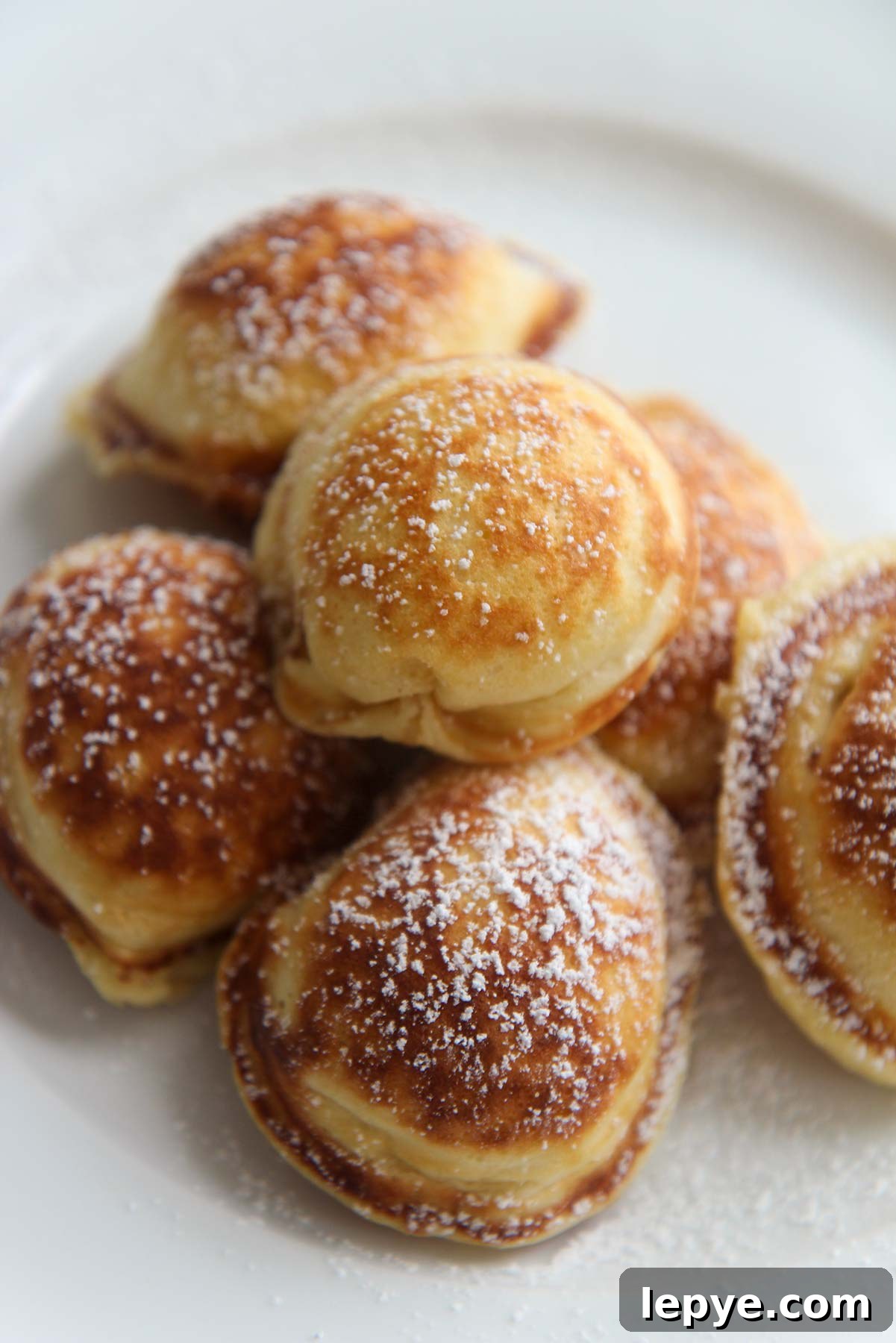 Mini Pancakes with powdered sugar on top, up close.