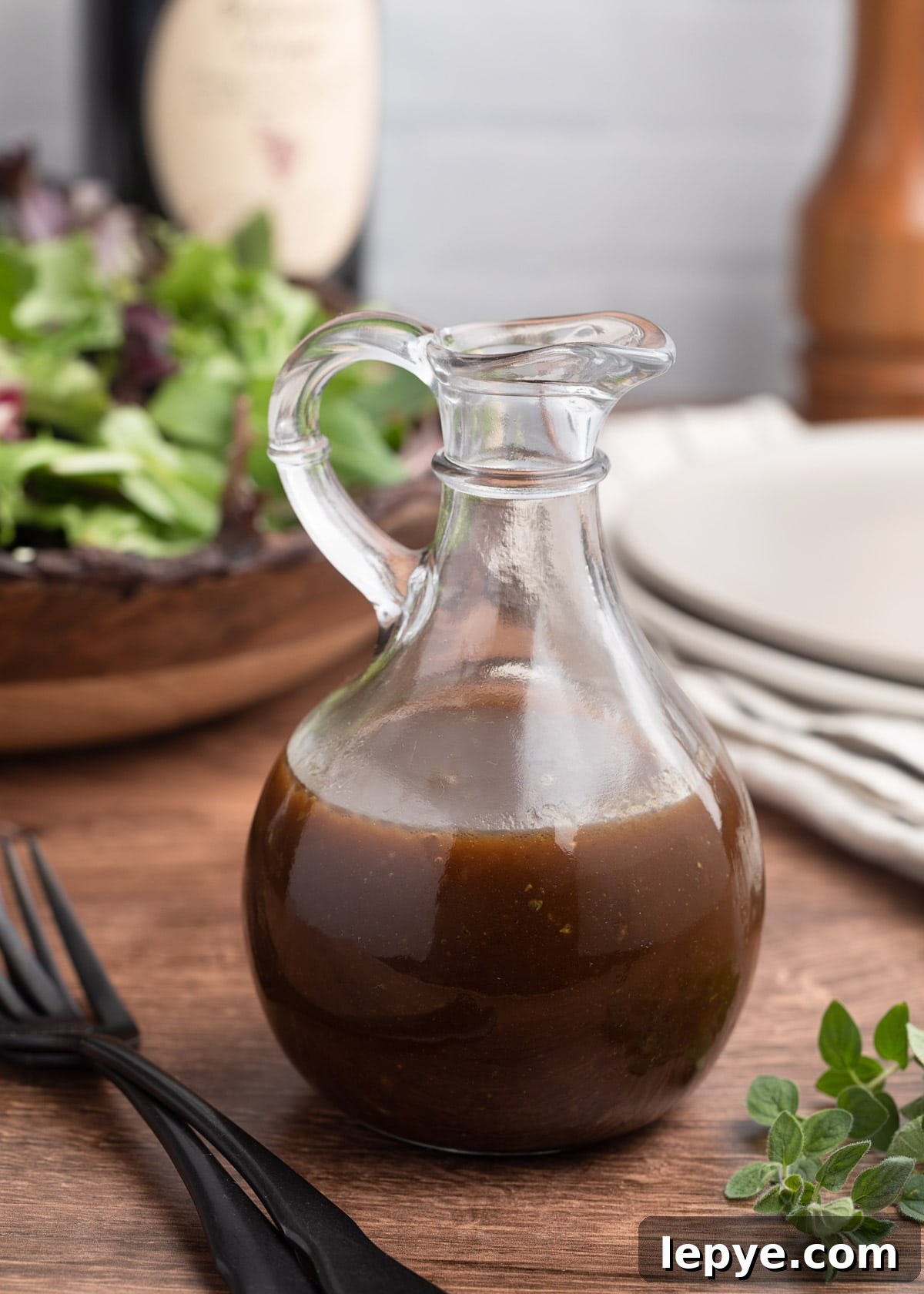 Classic Balsamic Vinaigrette Dressing Recipe 2 balsamic vinaigrette in a glass cruet in front of a bowl of spring mix lettuce