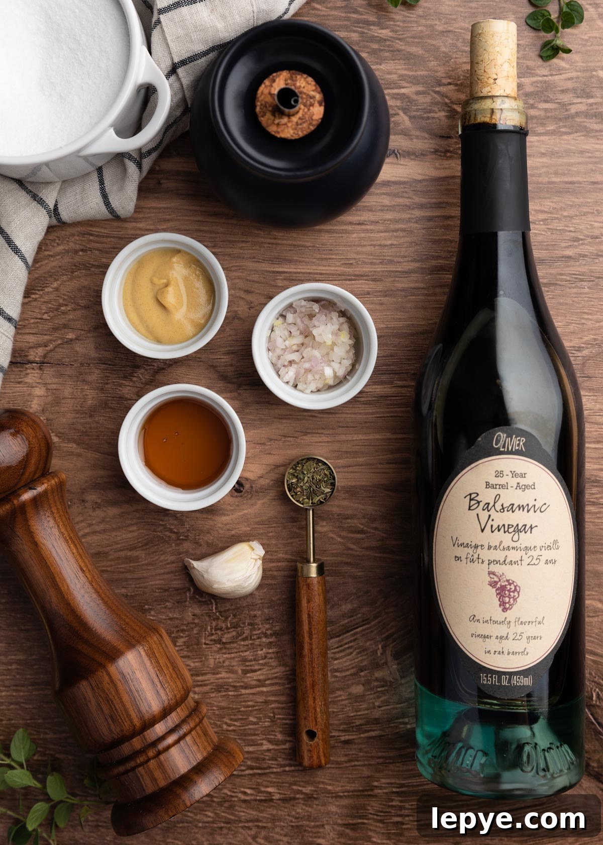Classic Balsamic Vinaigrette Dressing Recipe 3 overhead photo showing a bottle of balsamic vinegar and the ingredients for vinaigrette in pinch cups