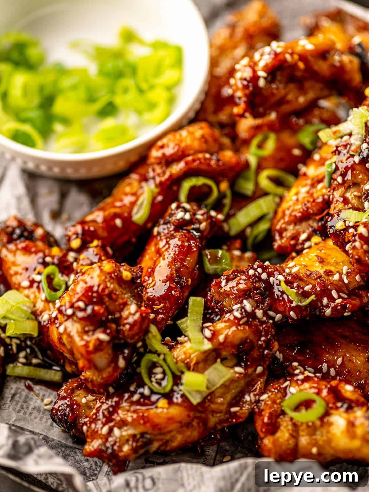 How to Reheat Chicken Wings: Air Fryer, Oven, or Stovetop 4 Chicken wings topped with scallions and sesame seeds.