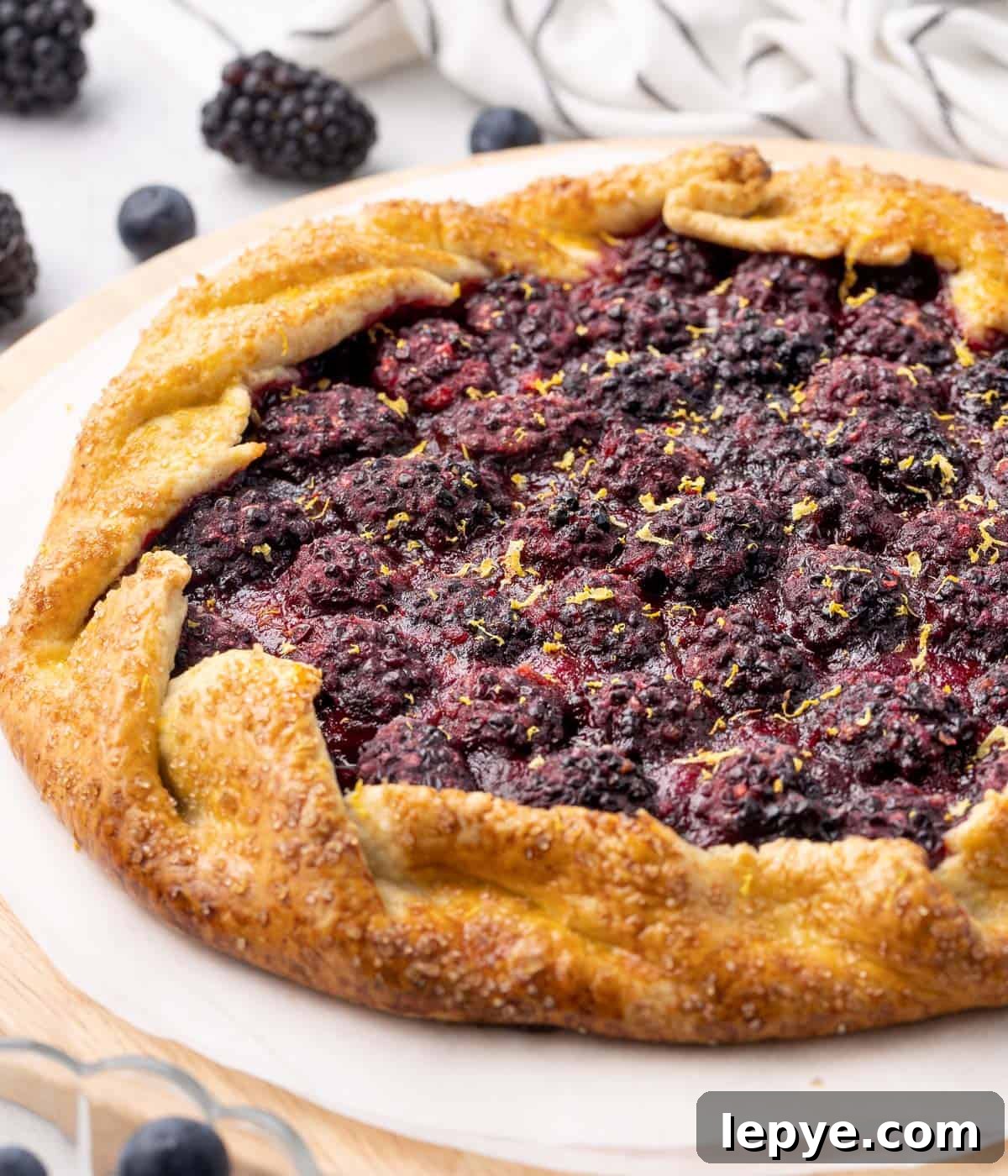 Side view on the galette placed over a round wooden board.