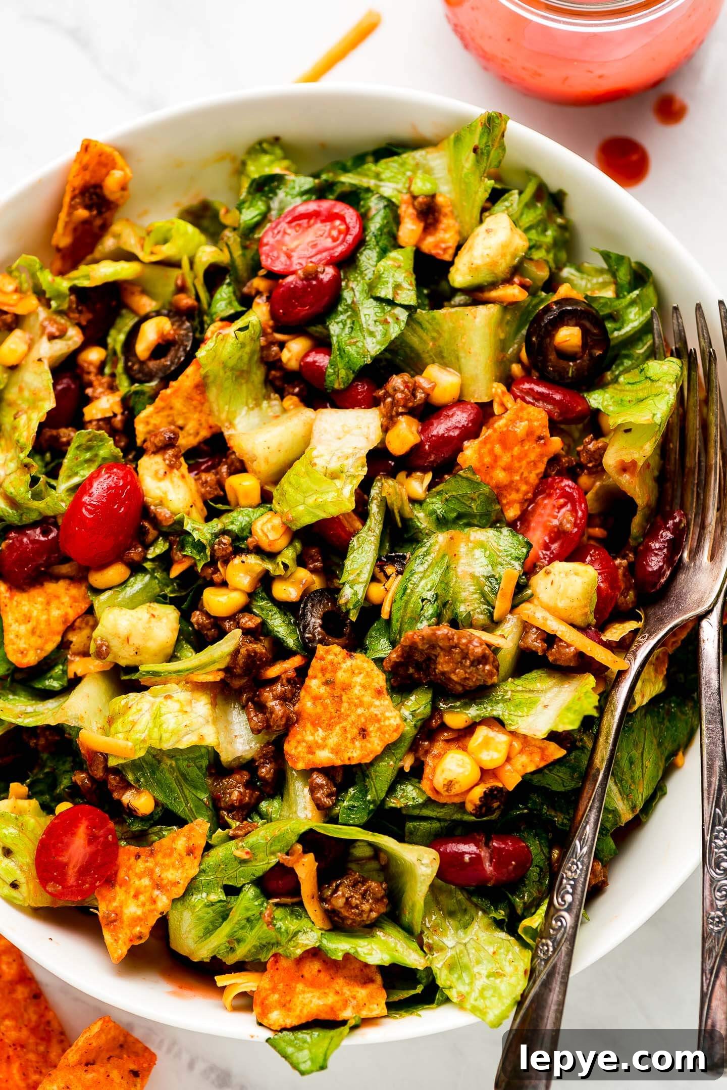Dorito Taco Salad Recipe: Crunchy Tex-Mex Dinner Idea 10 Dorito Taco Salad in a bowl tossed in dressing.