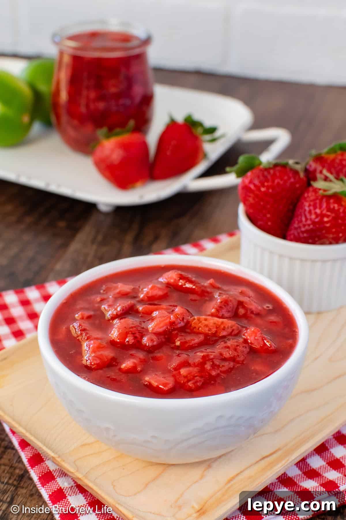 Homemade Strawberry Sauce Recipe for Desserts & Pancakes 6 A white bowl filled with a red strawberry sauce.