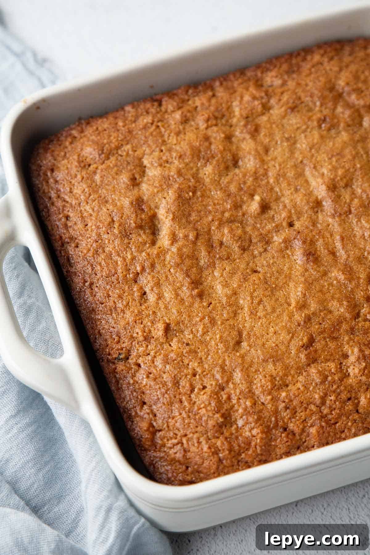 whole applesauce cake in a white square pan.