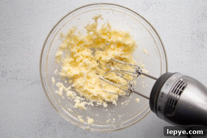 butter and sugar creamed together in a glass mixing bowl.