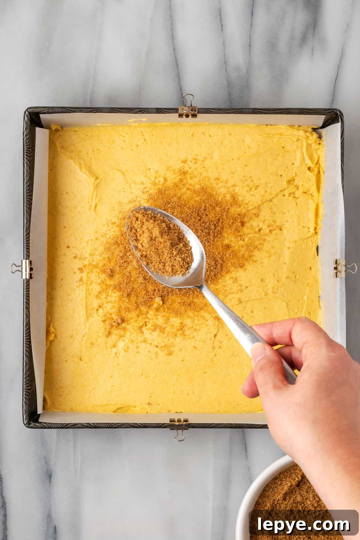 Pumpkin coffee cake batter in a square baking pan. 