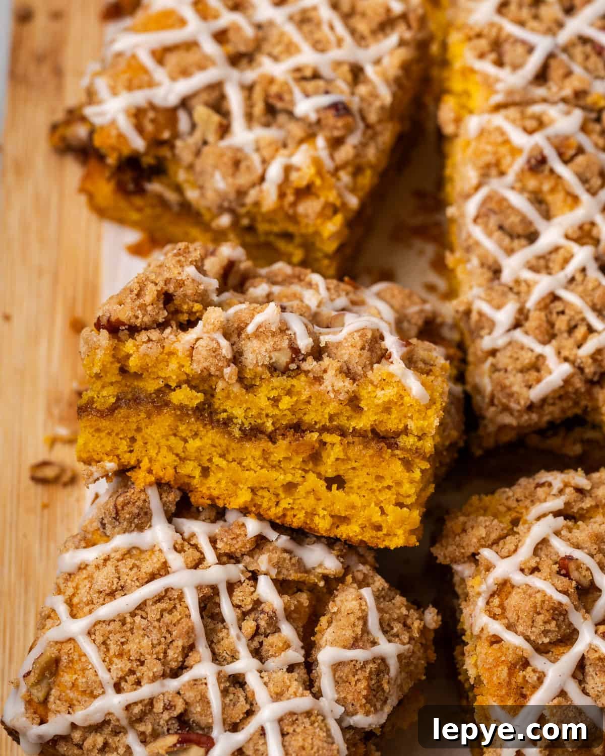 Slices of pumpkin coffee cake on a wood cutting board.
