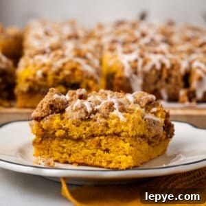 A slice of pumpkin coffee cake on a white plate.