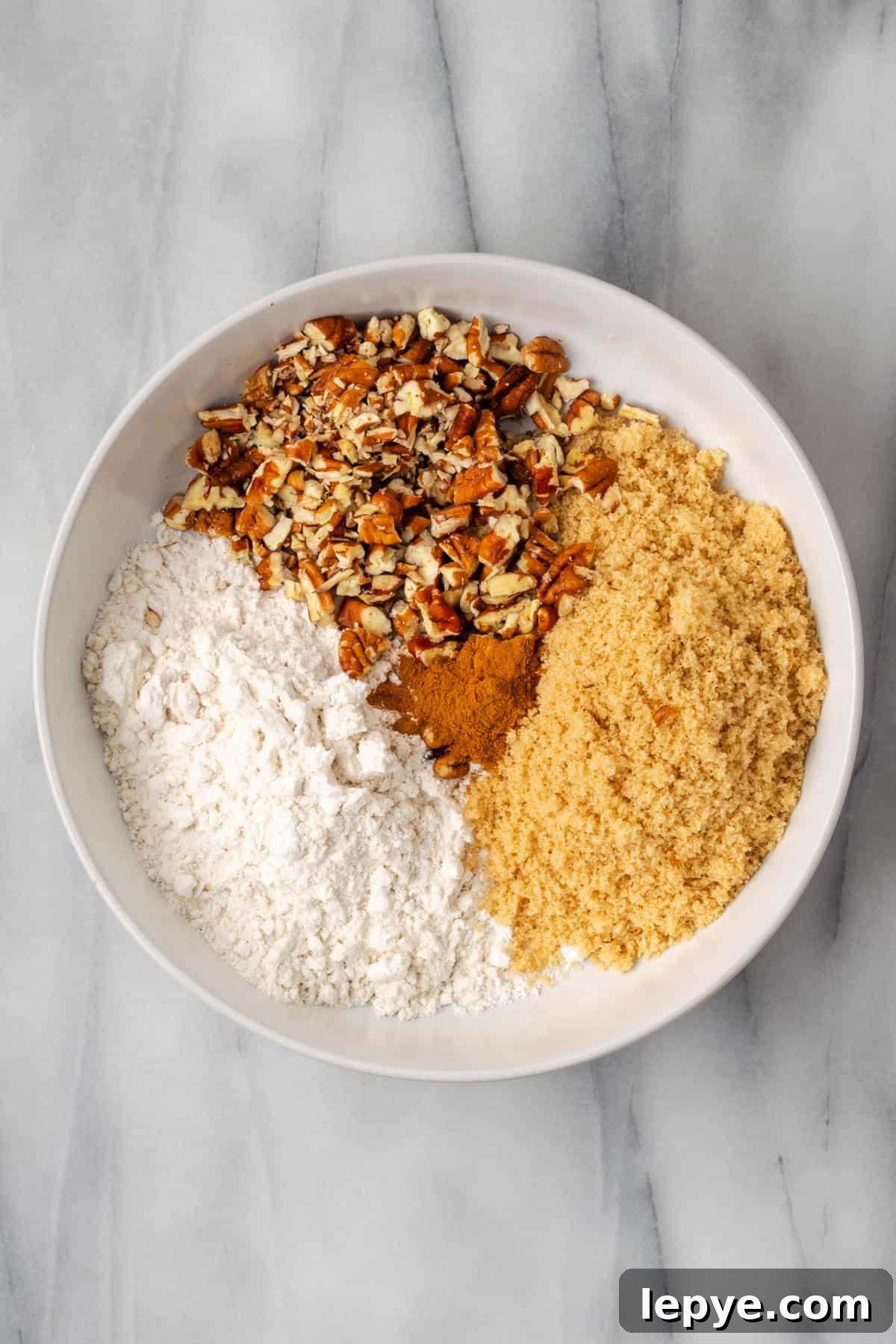 Gluten free flour, brown sugar, cinnamon and pecans combined together in a small bowl. 
